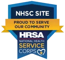 Blue and yellow badge reading "NHSC Site, Proud to Serve Our Community, HRSA National Health Service Corps.