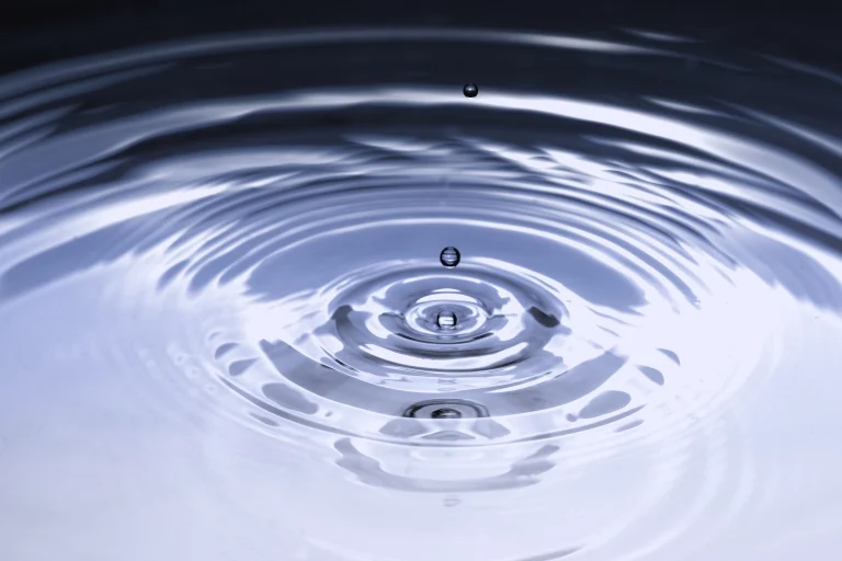 A droplet falls into water, creating concentric ripples.