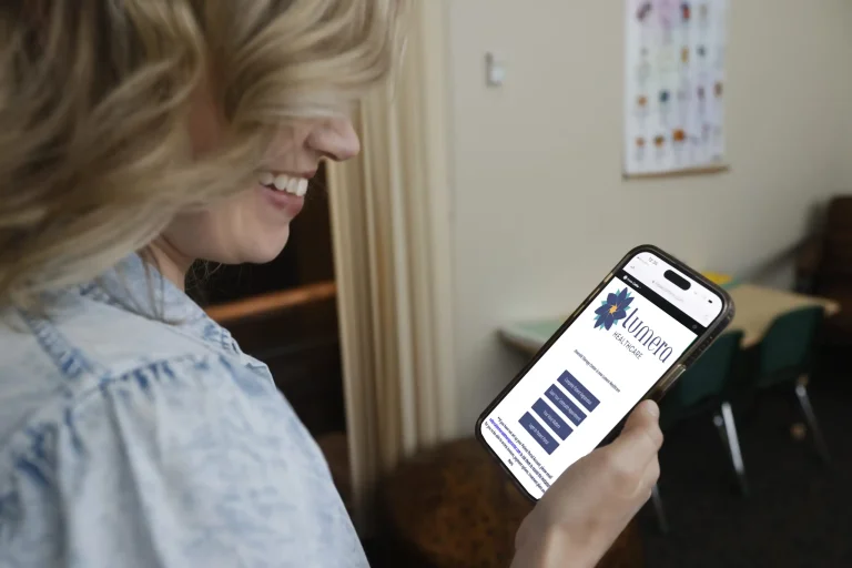 online therapy services Smiling woman looks at a healthcare website on her smartphone.