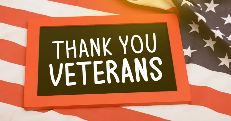 Chalkboard with "Thank You Veterans" on an American flag background.