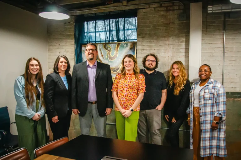 Lumer Healthcare team members standing together indoors, posing for a group photo in a professional office setting.